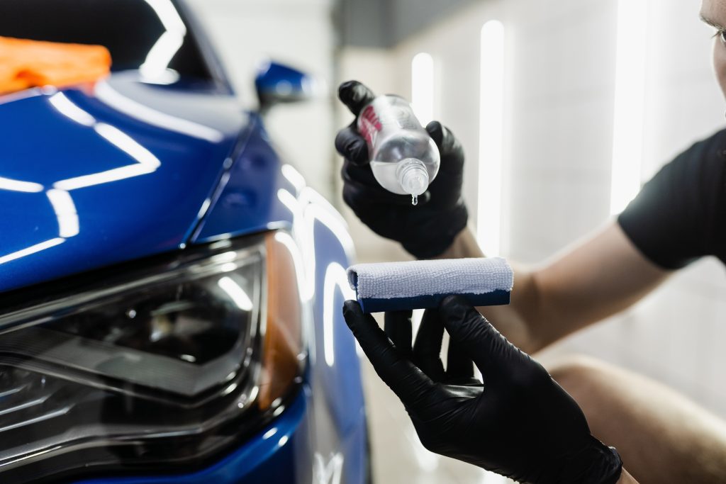 technician applying coating to a car